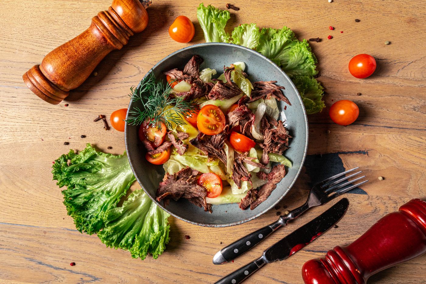 Steak and fresh vegetables served as a salad at the table