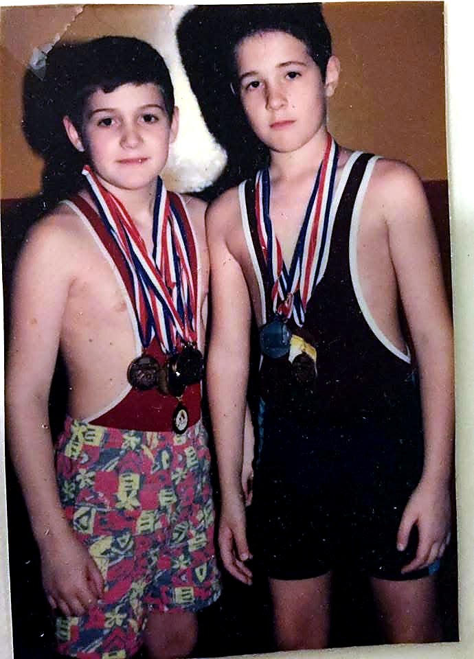 Wayne and Elijah as young wrestlers wearing medals